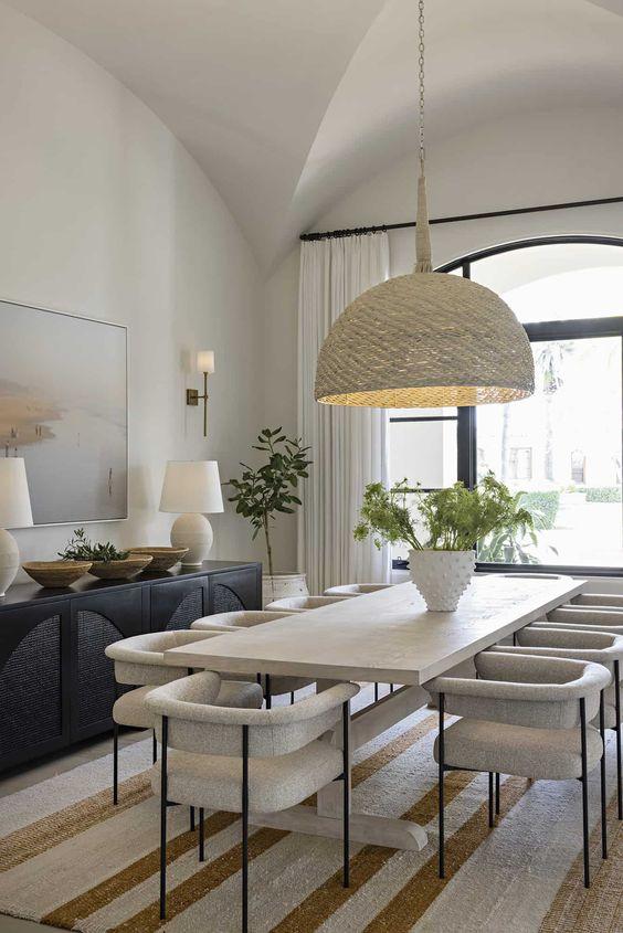 Love this chic modern beach house style dining room idea with curved dining chairs, striped rug, and woven pendant light - home decor style - modern coastal home - interior design inspo - organic modern decor - intimate living interiors