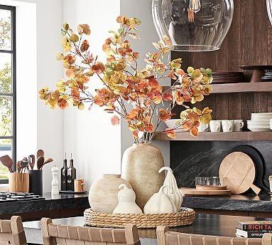 Fall kitchen styling with faux branches and gourds in a round woven basket tray - pottery barn