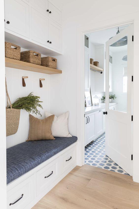 Love this beautiful mudroom and laundry room design with white cabinets and creative storage and seating solutions - pure salt interiors