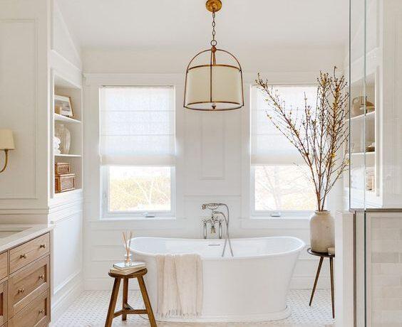 Love this beautiful bathroom design with a light wood vanity, free-standing tub, and light neutral decor - akb design studio