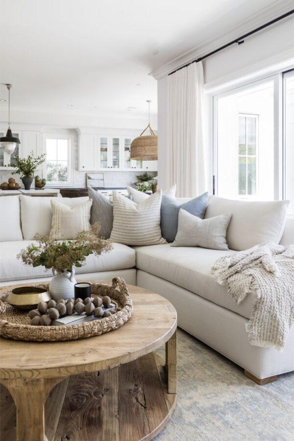 Beautiful beach house style living room with sectional and round wood coffee table - pure salt interiors