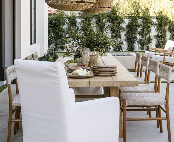 Love this beautiful modern coastal style patio and outdoor dining area with a wood dining table and woven pendant lighting - pure salt interiors
