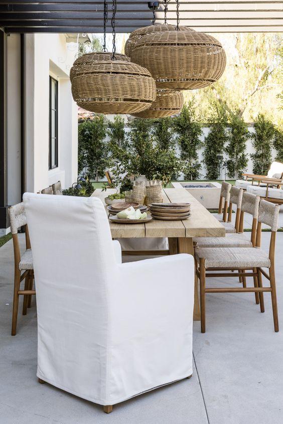 Love this beautiful modern coastal style patio and outdoor dining area with a wood dining table and woven pendant lighting - pure salt interiors