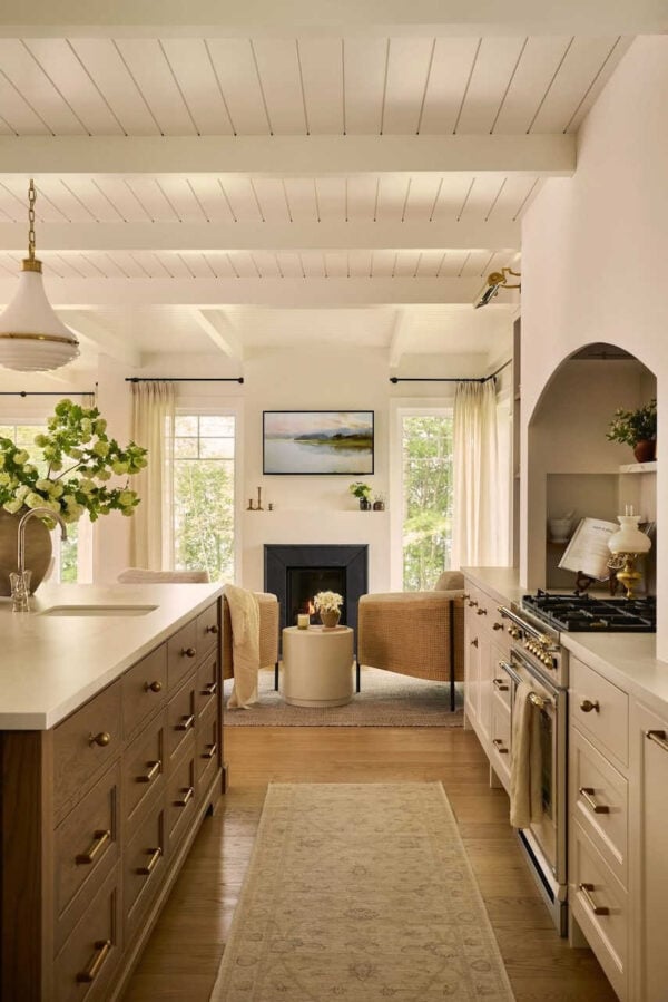 Luxury warm white kitchen with large island, quartz countertops, and pendant lighting.