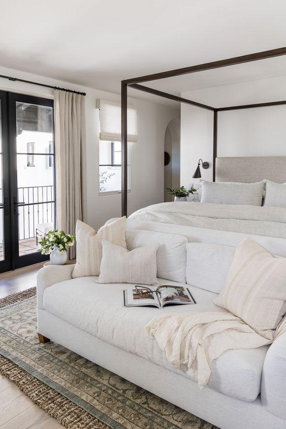 Love this beautiful bedroom design with a neutral color palette, canopy bed, and settee at the end of the bed - pure salt interiors