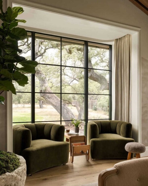 Modern corner featuring sculptural lounge chairs and side table in a soft neutral palette.