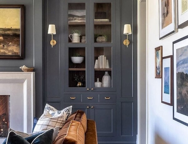 Light-filled living room featuring a curved sofa and warm ambient lighting from brass sconces, showcasing 2026 home décor trends and color palette