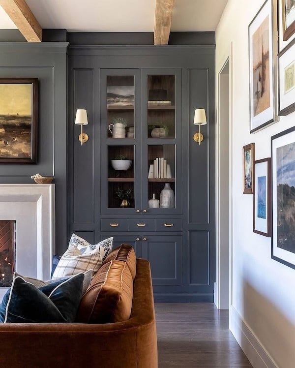 Light-filled living room featuring a curved sofa and warm ambient lighting from brass sconces, showcasing 2026 home décor trends and color palette