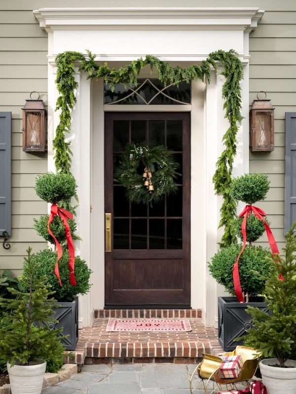 Beautiful Christmas front porch with garlands and topiaries - studio mcgee