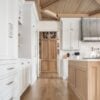 Love this beautiful white kitchen design with herringbone wood floors - a guide to standard kitchen cabinet dimensions, including base, upper, corner, and tall pantry cabinets
