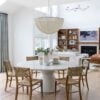 Love this beautiful modern coastal dining area and living room with a round dining table, woven dining chairs and a statement chandelier - open concept home - dining room ideas - coastal style