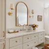 Love this beautiful timeless bathroom design with a curved wall mirror and brass sconces - akb design studio