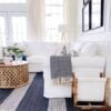 A white slipcovered sectional sofa and striped rug add a touch of relaxed summer style to our living room - jane at home #decor #design #homedecorideas #style